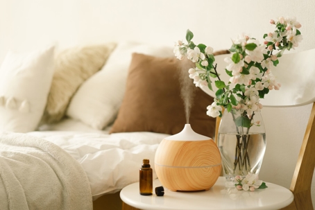Aromatherapy Concept. Aroma oil diffuser on chair against in the bedroom. Air freshener. Ultrasonic aroma diffuser for home